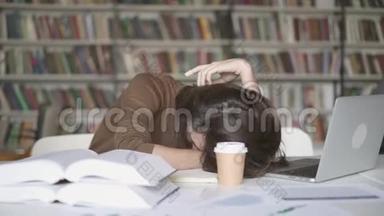 一个疲惫的男学生在图书馆睡着了